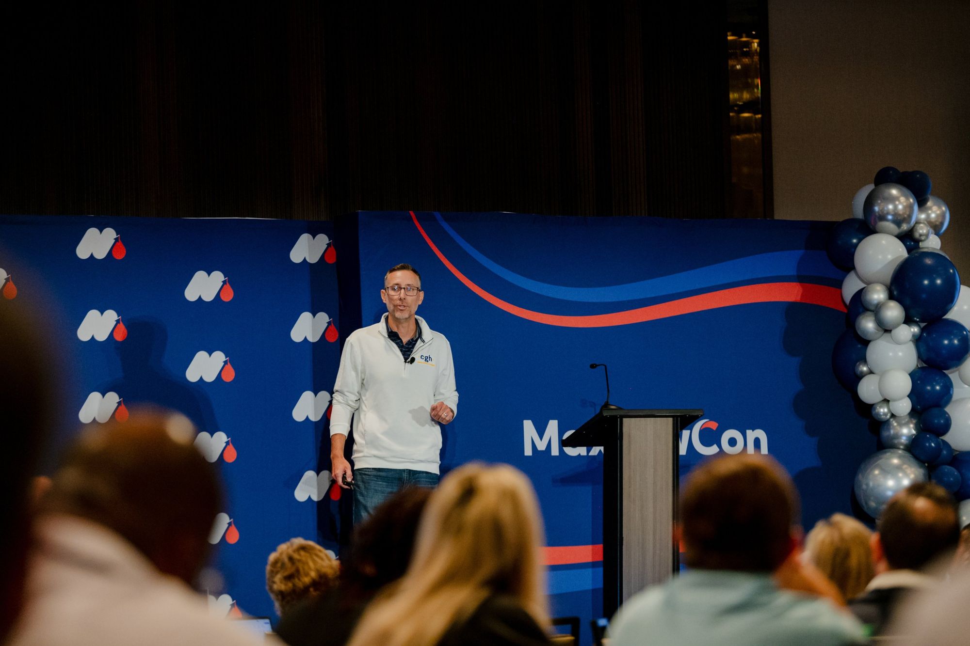 Travis on stage at MaxLawCon, seen from the back of the room